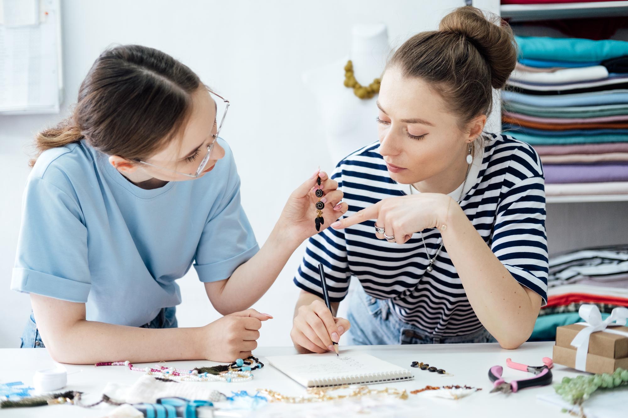 Teacher guiding student in embroidery studio