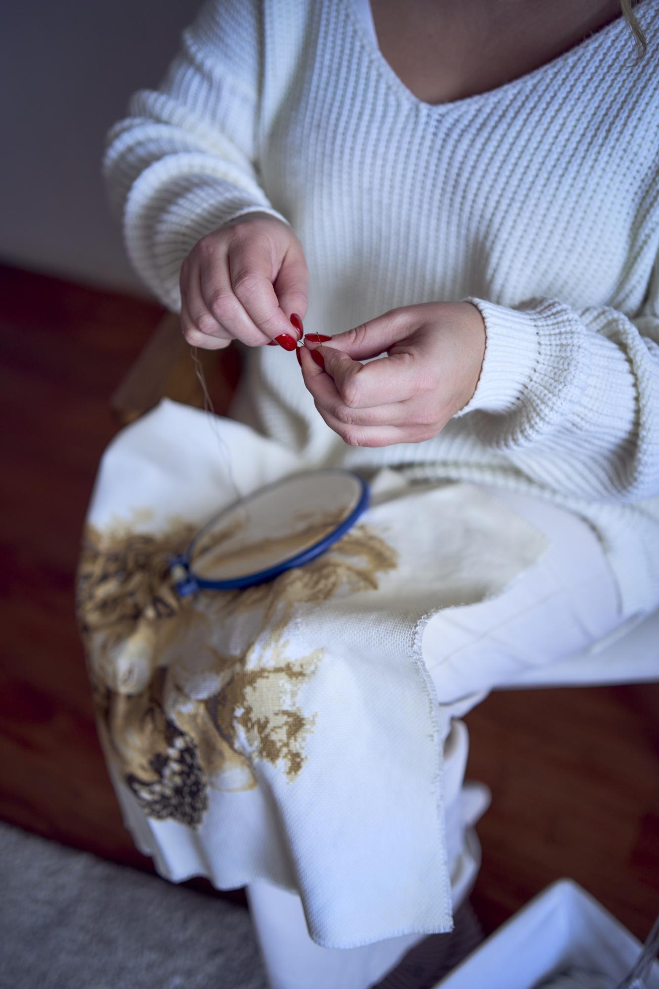 Close-up of hand embroidery on linen with warm threads